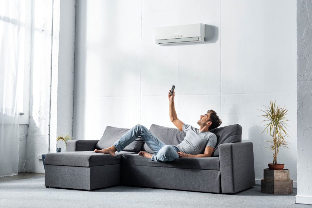 A man using the air conditioner in his home