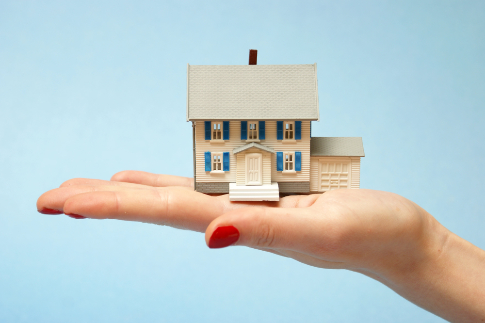 An image of a tiny model house in a person's hand